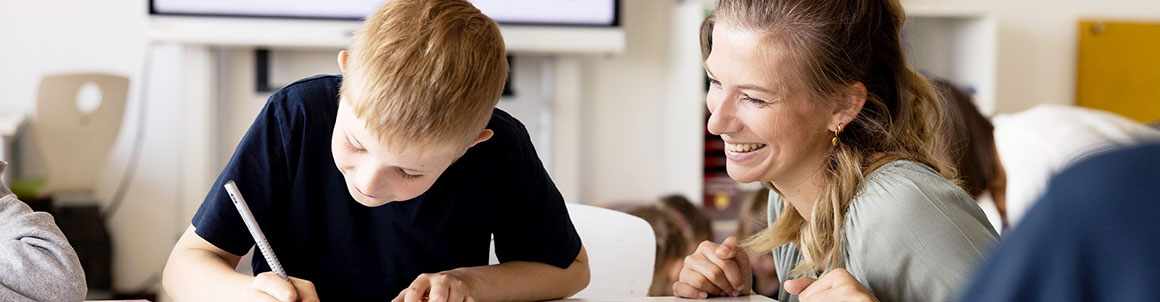 Projektmitarbeiter am Schreibtisch sitzend mit einem Buch in der Hand.