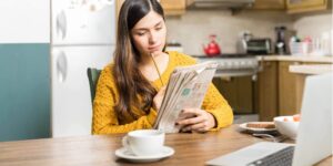 Frau liest Stellenanzeige in Zeitung