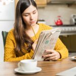 Frau liest Stellenanzeige in Zeitung
