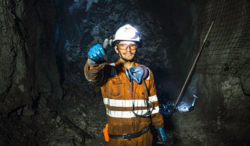 Aufbereitungsmechaniker bei Kohleabbau im orangen Anzug mit Sicherheitsschutz