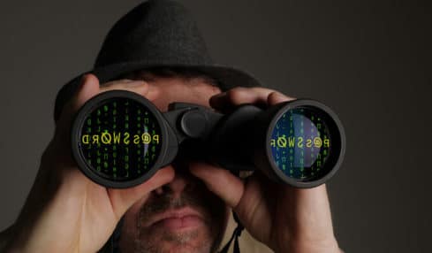 Ein Beamter im mittl. Dienst Verfassungsschutz mit einem Fernglas zur Sammlung von Informationen