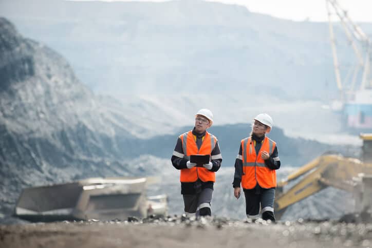 2 Bergbautechnologen (rechts: weiblich, links: männlich) während der Arbeit.