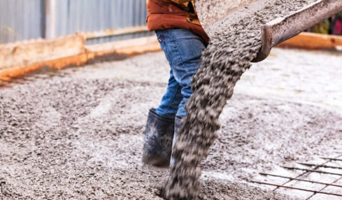 Ein Beton- und Stahlbetonbauer beim Beton gießen