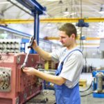 Anlagenmechaniker während der Ausbildung beim Bedienen einer Maschinenanlage