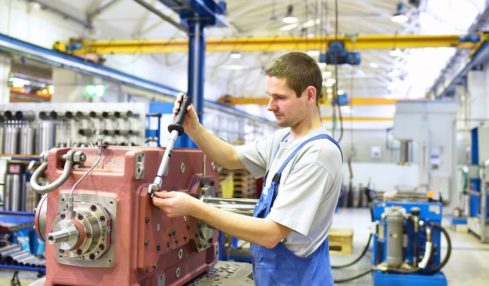 Anlagenmechaniker während der Ausbildung beim Bedienen einer Maschinenanlage