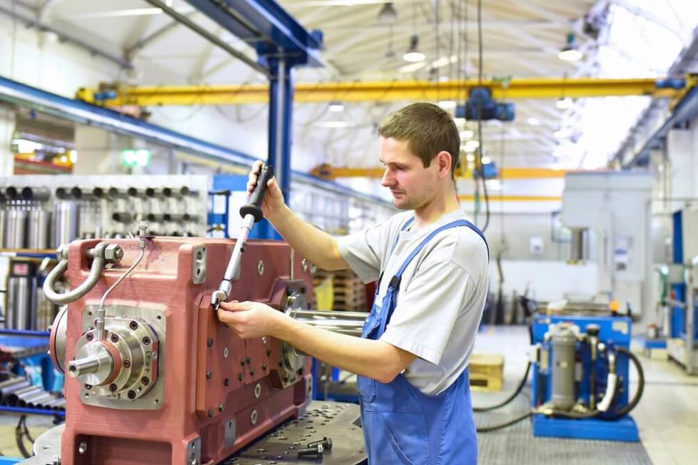 Anlagenmechaniker während der Ausbildung beim Bedienen einer Maschinenanlage