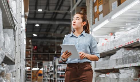 Fachkraft für Lagerlogistik prüft Warenbestand
