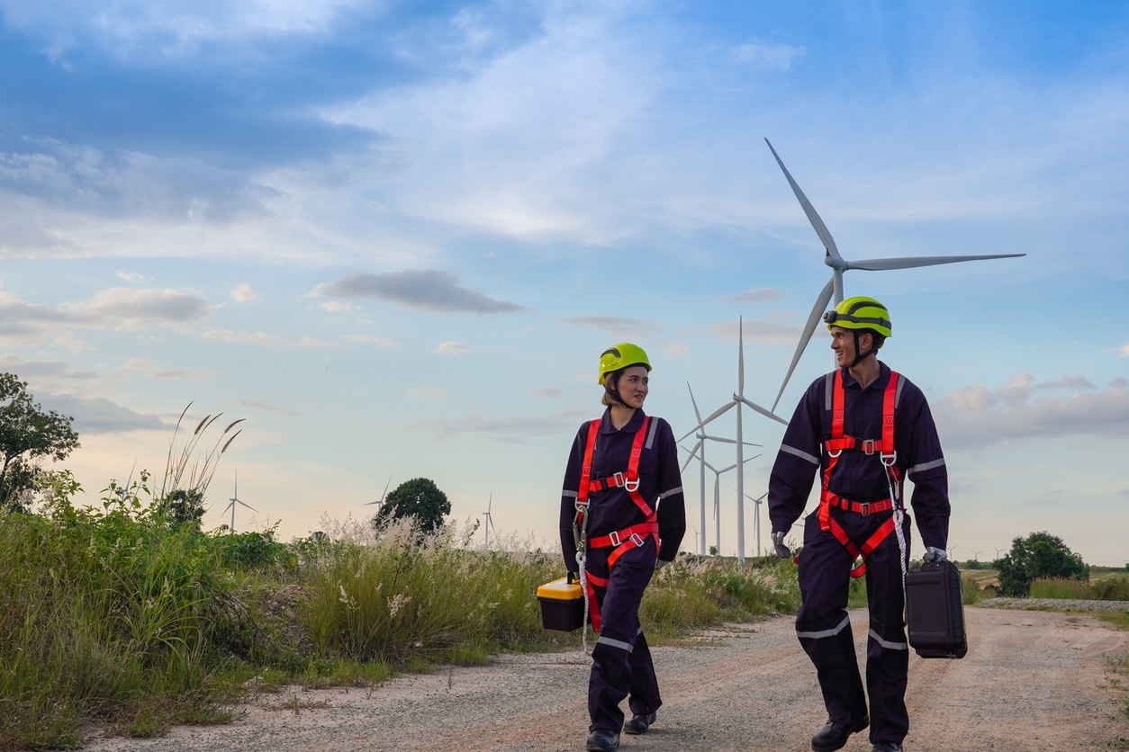 Zwei junge Windkraft-Ingenieure kommen von der Wartung eines Windrad zurück