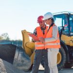 Zwei Straßenwärter (rechts weiblich, links männlich) auf einer Baustelle.