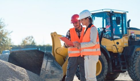 Zwei Straßenwärter (rechts weiblich, links männlich) auf einer Baustelle.