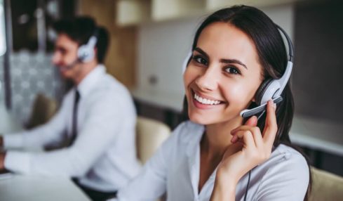 Eine angehende Kauffrau für Dialogmarketing mit Headset in der Arbeit während der Kaufmann für Dialogmarketing Ausbildung