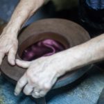 Ein Hut wird per Hand von einem Modisten bearbeitet