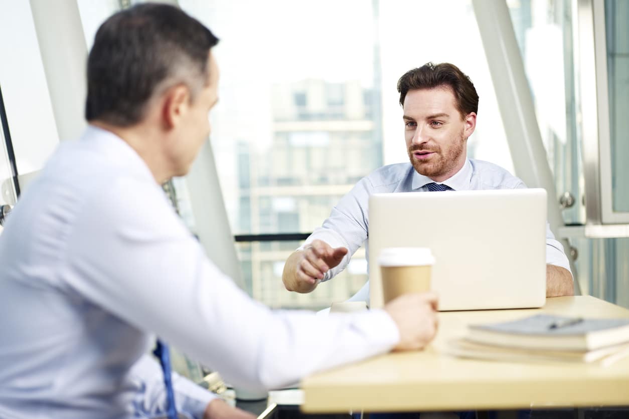 Chef und Arbeitnehmer sitzen beim Mitarbeitergespräch
