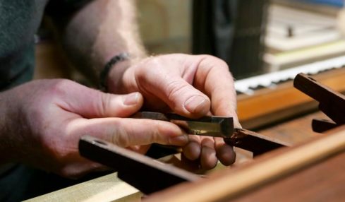Ein Orgelbauer in der Ausbildung bei einer spezialisierten Reparatur der Orgel