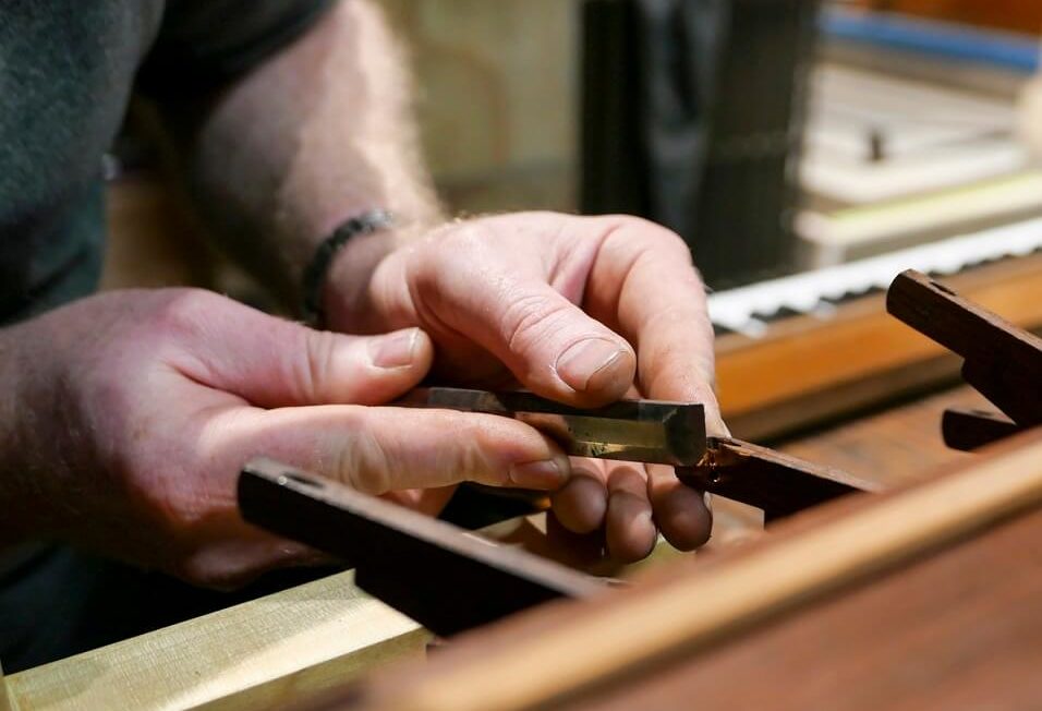 Ein Orgelbauer in der Ausbildung bei einer spezialisierten Reparatur der Orgel