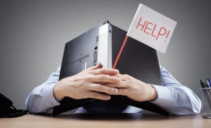Berufe ohne Zukunft: Mann versteckt sich hinter Laptop, mit Schild "help" in der Hand