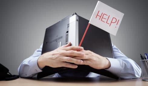 Berufe ohne Zukunft: Mann versteckt sich hinter Laptop, mit Schild "help" in der Hand