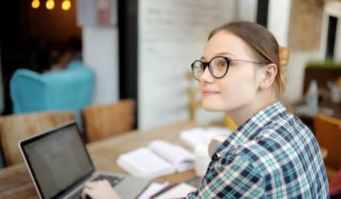 Studentin schreibt am Laptop Praktikumsbericht