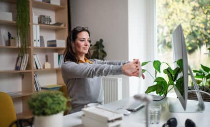 Frau am Arbeitsplatz dehnt sich