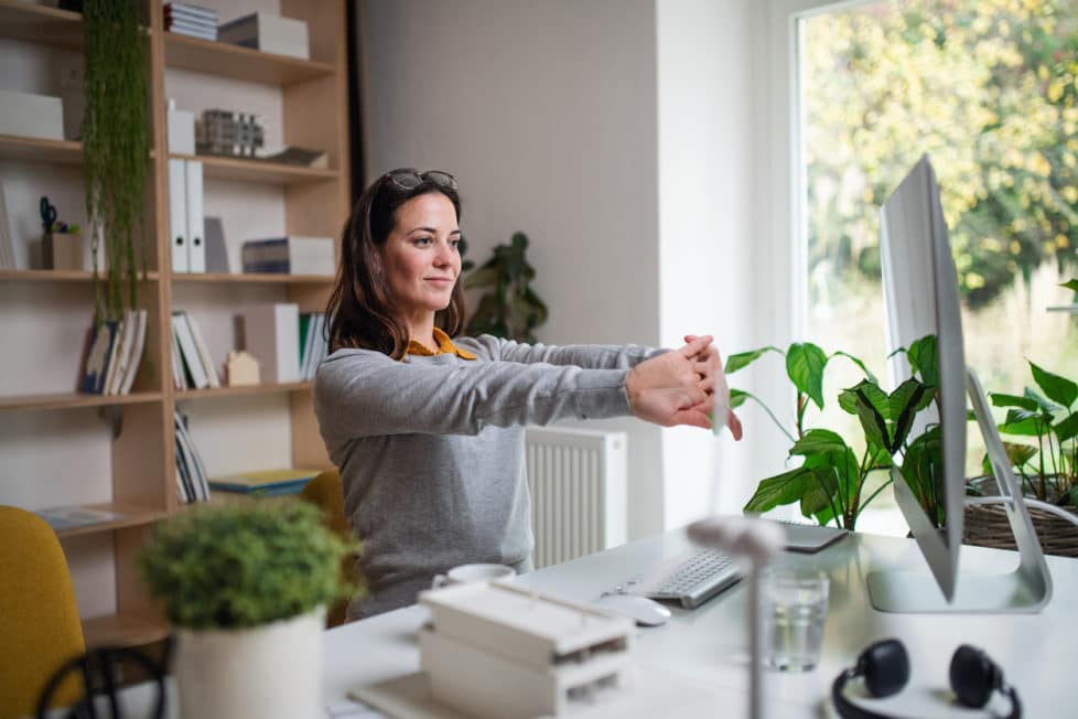 Frau am Arbeitsplatz dehnt sich