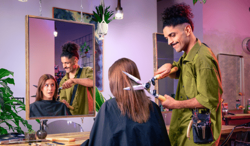 Friseur schneidet Kundin mit Heckenschere die Haare