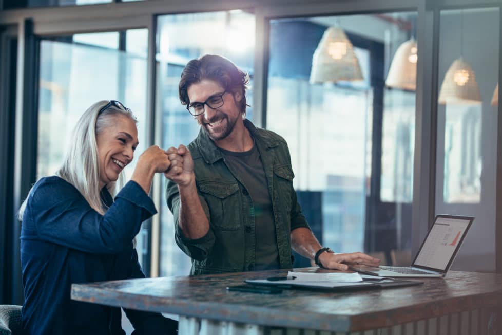 Mann und Frau freuen sich in der Arbeit