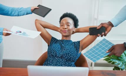 Arbeitnehmerin lehnt sich entspannt zurück, während ihr Arbeit vorgehalten wird - Quiet Quitting