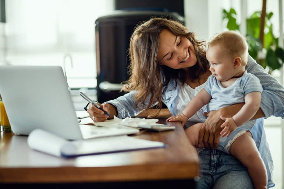 Mutter mit Kind arbeitet im Homeoffice