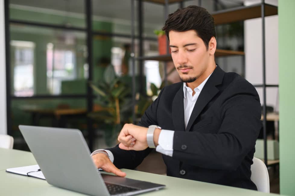 Mann schaut auf die Uhr wegen Pomodoro-Technik