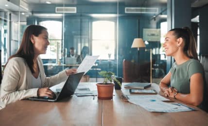 Junge Frau bei Mitarbeitergespräch mit Chefin im Büro