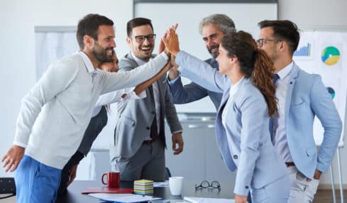 Team in Büro klatscht ab - Teamfähigkeit