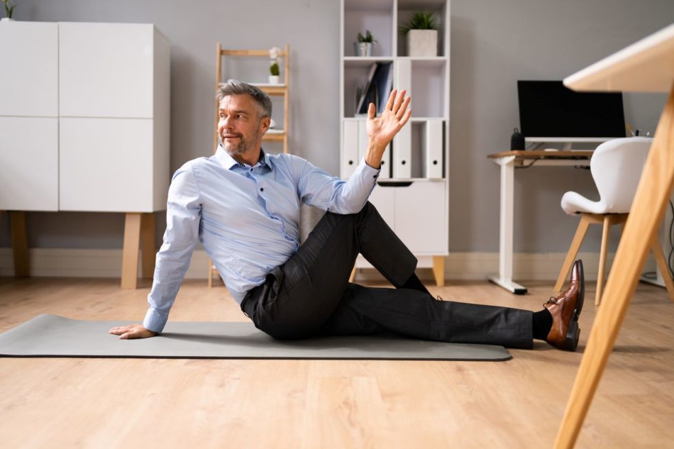 Mann macht Yoga im Büro - gegen Müdigkeit