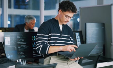 Man, programmer and office with laptop for coding, software development or app design. Male person, coder or developer with computer or technology for cybersecurity, web or IT services at workplace