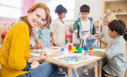 Teacher and students painting in classroom