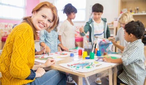 Teacher and students painting in classroom