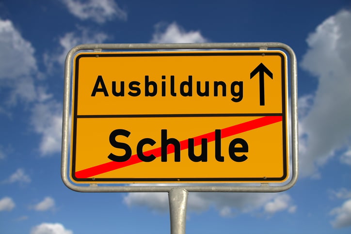 German road sign school and apprenticeship with blue sky and white clouds