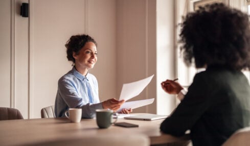 A friendly conversation during a business meeting in a well-lit modern office space, highlighting collaboration and teamwork.