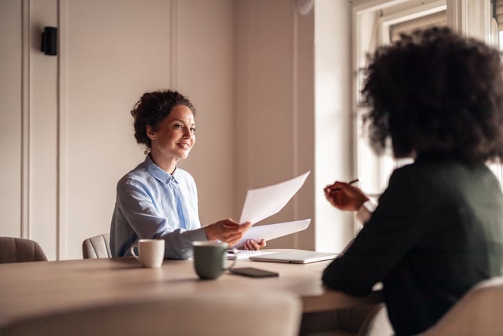 A friendly conversation during a business meeting in a well-lit modern office space, highlighting collaboration and teamwork.